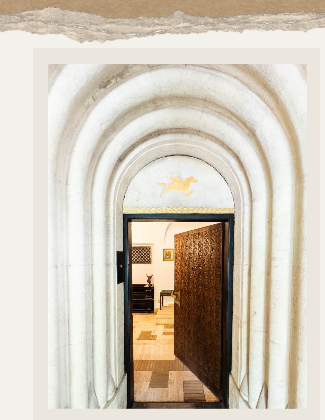 An entrance of successive white arches leading to a solid wood door at Vila Tătărescu
